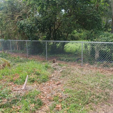 Finished galvanised chain link fence and gate across an open lot