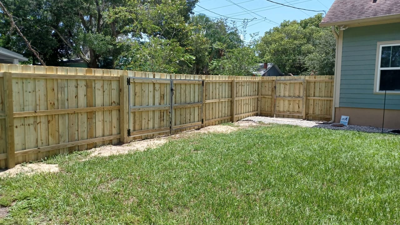 Una cerca de privacidad en madera instalada por Marquez Yera Fence en un patio verde de Orlando