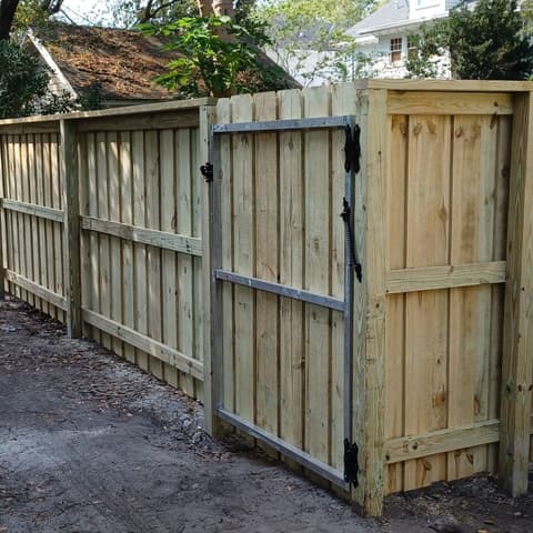 Wood privacy fence and gate running down a side alley